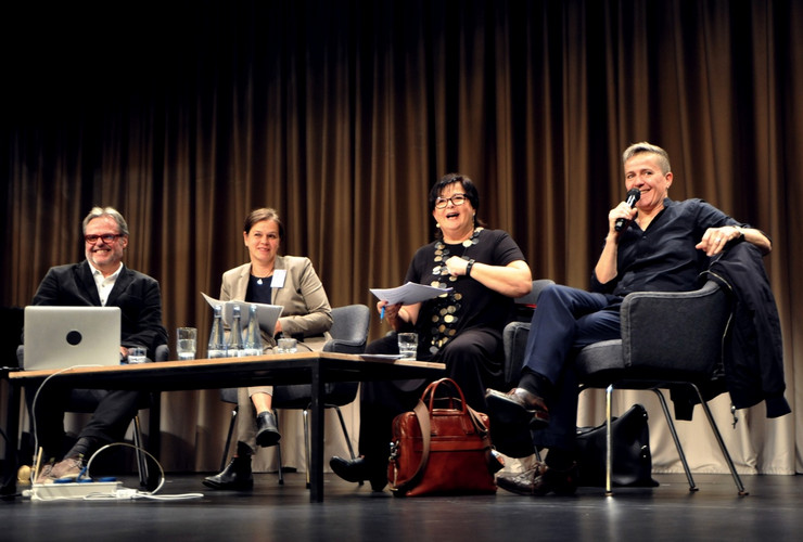 Four people on stage in conversation