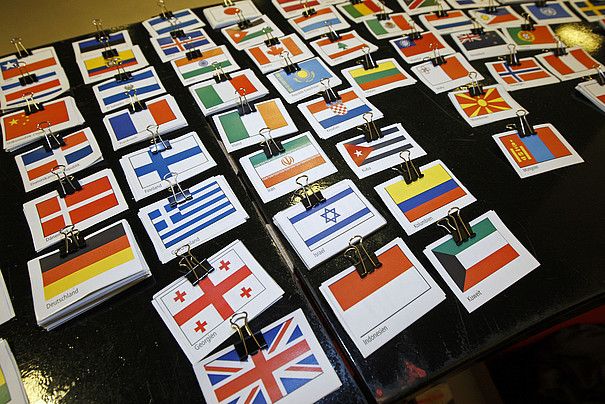 Kleine Flaggen aus verschiedenen Ländern auf einem Tisch.