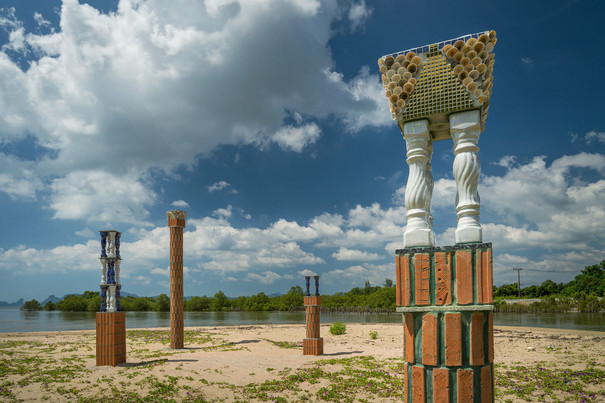 Skulpturen in der Landschaft im Hintergrund blauer Himmel mit Wolken