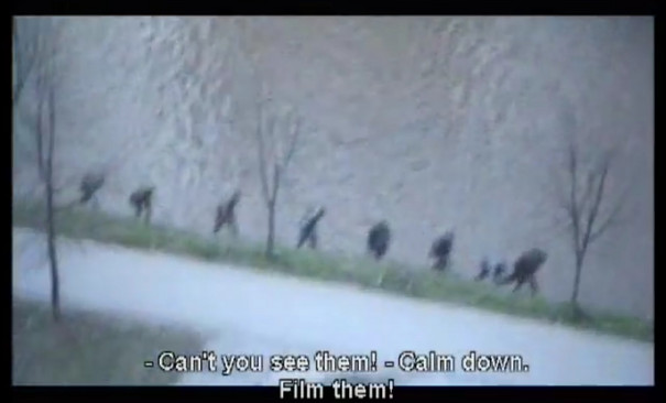 A still from a video where people hike hillside.
