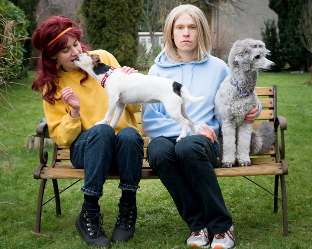The performers on a bench with dogs.