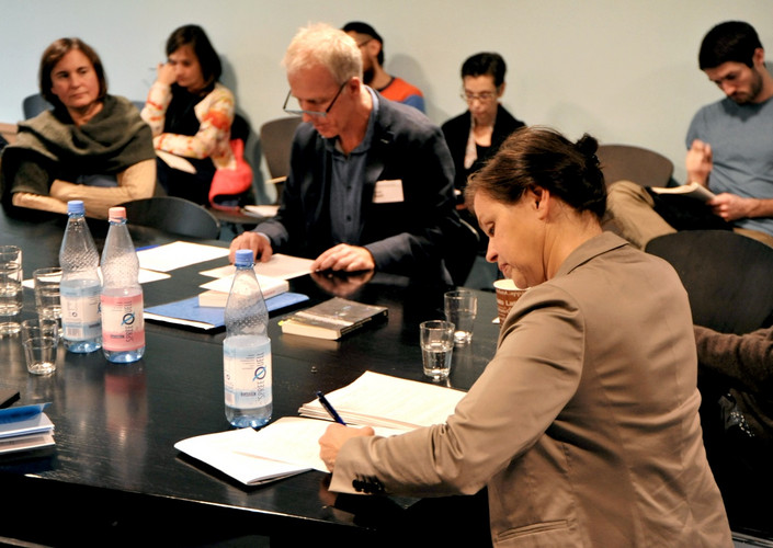 People sitting at table writing.