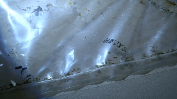 Durchsichtige Plastikfolie mit 'Beuys' Schriftzug  auf weißem Untergrund.