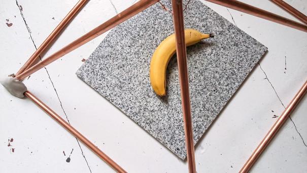 Exponat: Banane in pyramidenförmigen Konstrukt