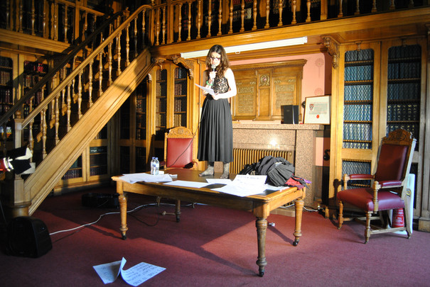 The artist Tanja Ostojić stands on a table during her performance of “Naked Life 6” at the Society of Advocates Hall, Aberdeen Scotland.