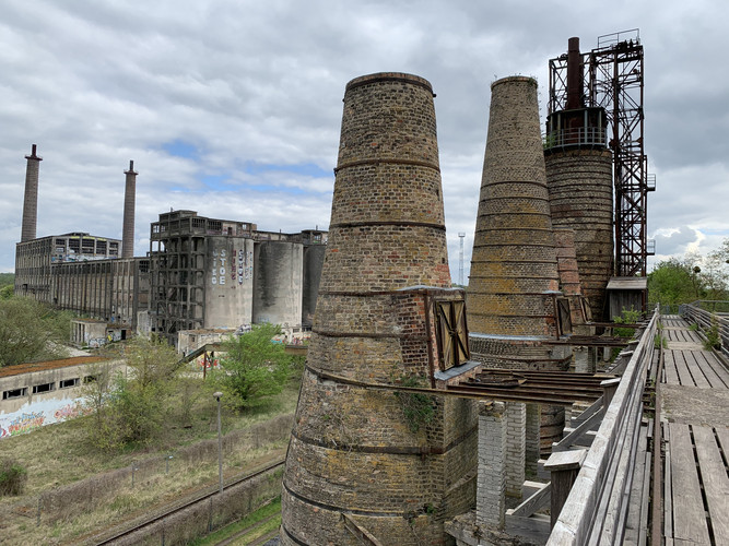 Blick auf die alten kegelförmigen Kalköfen. Im Hintergrund der Rest der verfallenen Industrieanlage.