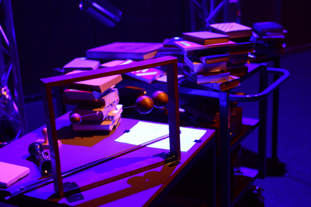 Piles of books on tables in violet light.