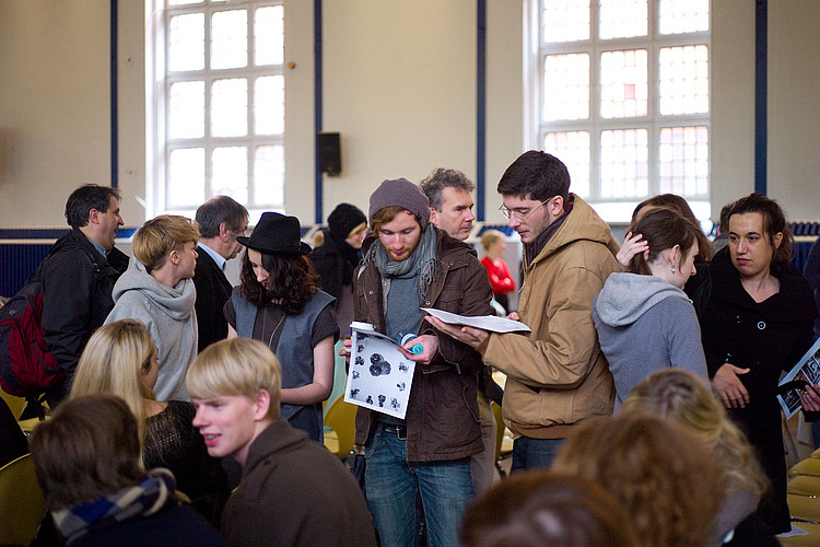 Eine Gruppe von jungen Leuten informiert sich über eine Veranstaltung.
