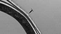 Jumping from a bridge in black and white