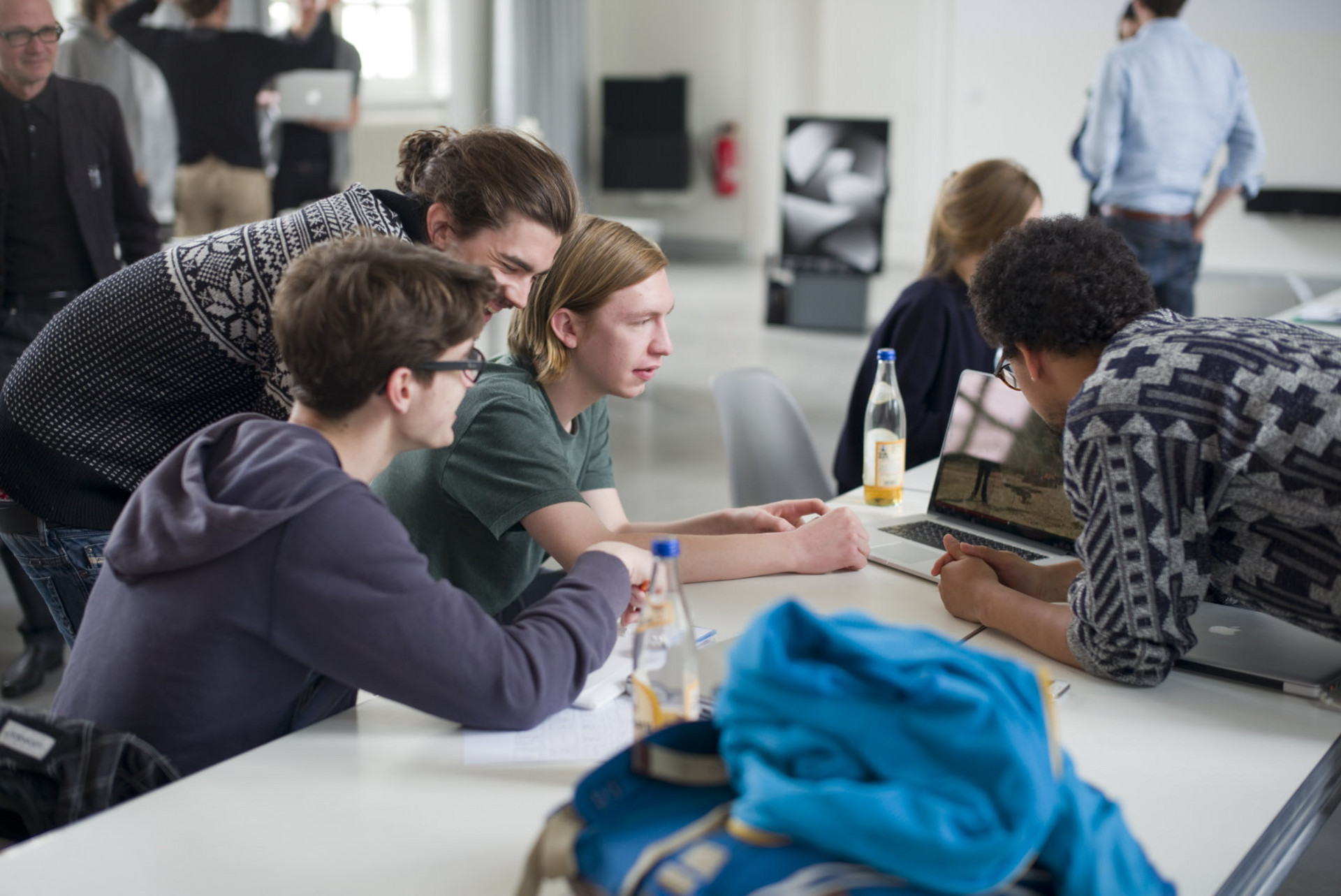 Studierende, die sich um ein Laptop gruppieren.