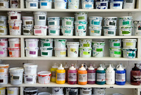 Ein Bild mit vielen Farbcontainern und Farbeimern.